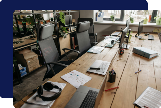 An unorganized corporate office workspace with cluttered desks